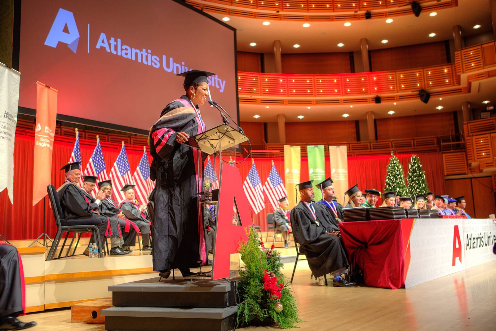 Atlantis University graduation ceremony, with graduates in gowns on stage