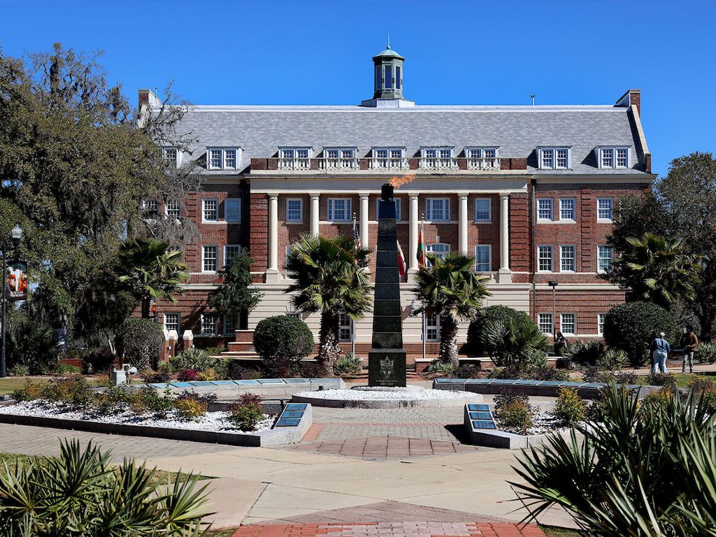 The Eternal Flame monument in front of Lee Hall, among palms and live oaks, on the FAMU campus