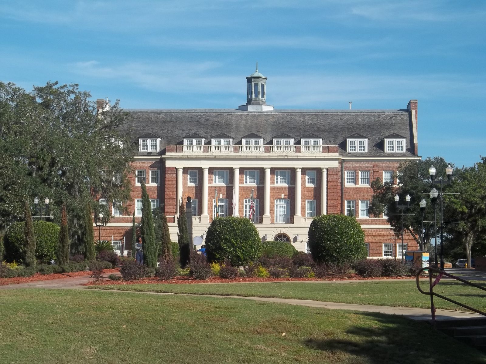 Lee Hall, Florida A&M University's historic red-brick building with white columns and a cupola, seen from the campus lawn in Tallahassee on a sunny day