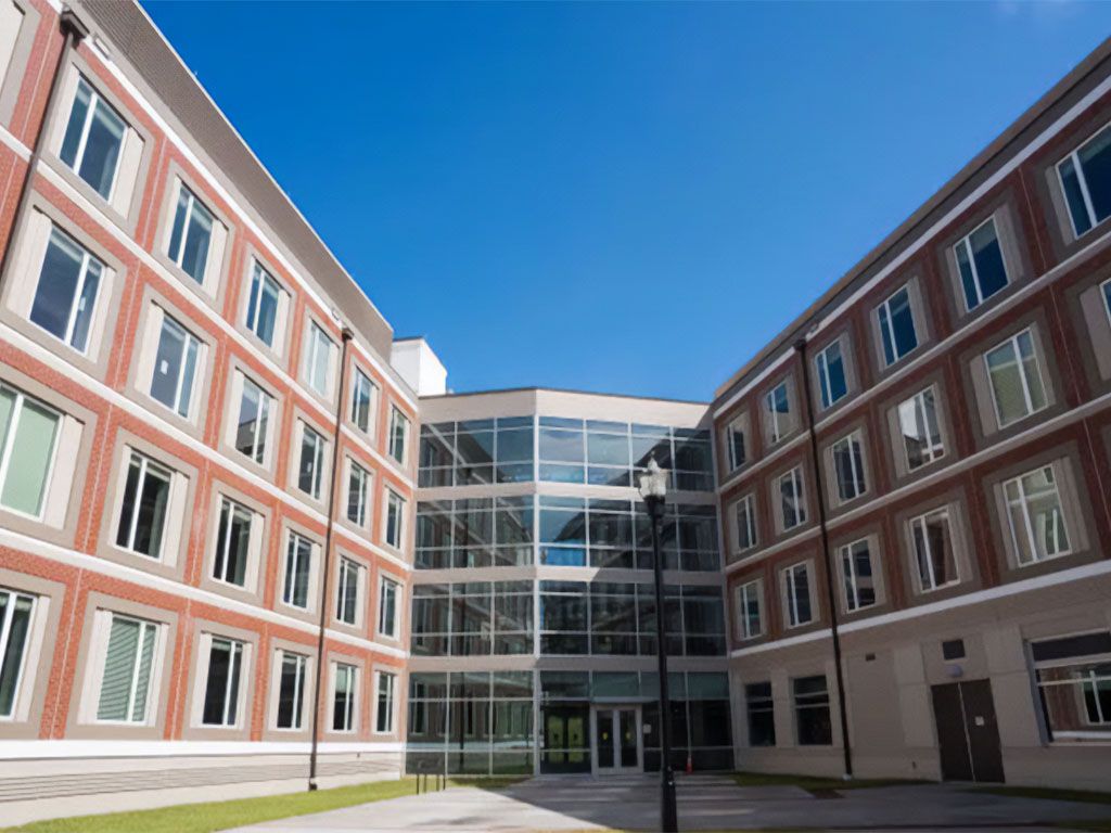 Exterior of Venom Landing, the 700-bed residence hall opened at FAMU in August 2025, with red brick and a glass entrance