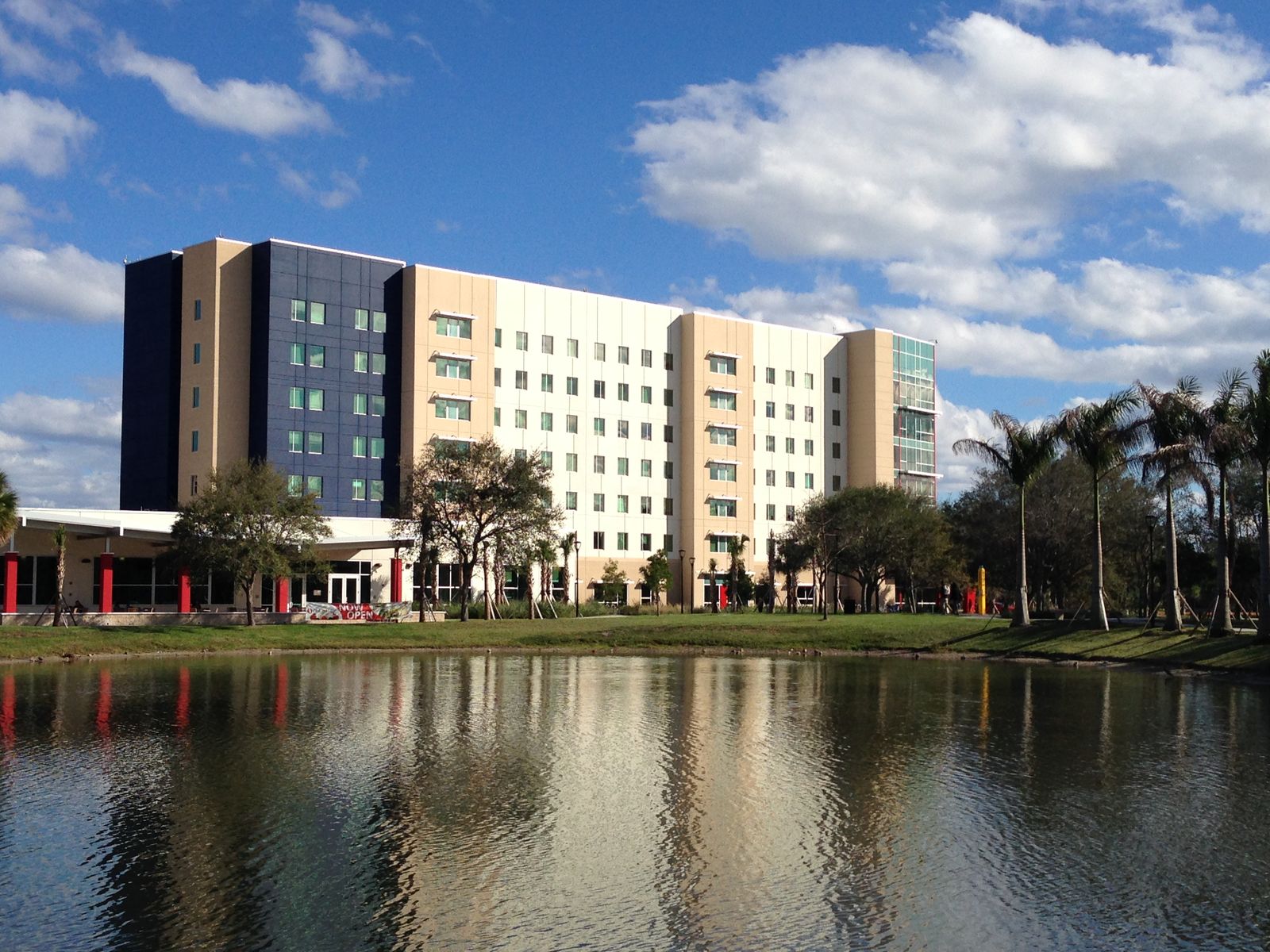 Parliament Hall, FAU's freshman residence hall in Boca Raton, reflected in the campus lake on a blue-sky day