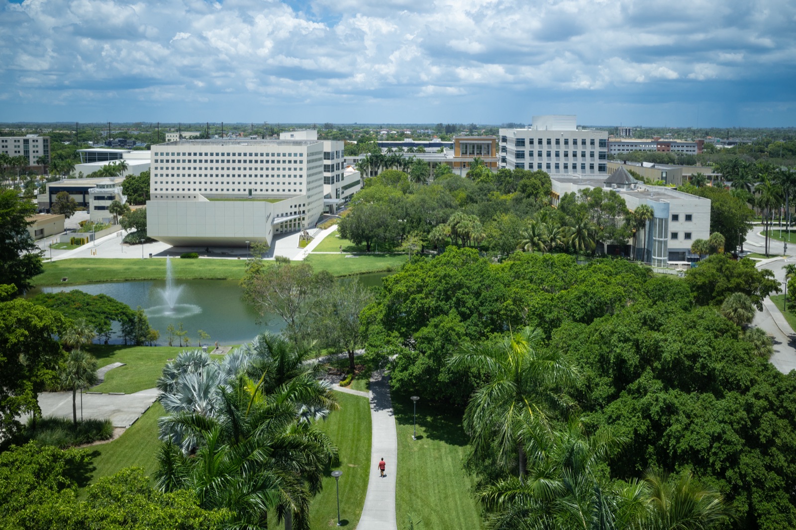 Aerial view of FIU's Modesto A. Maidique Campus, with the lake, the fountain, lawns and academic buildings among the trees