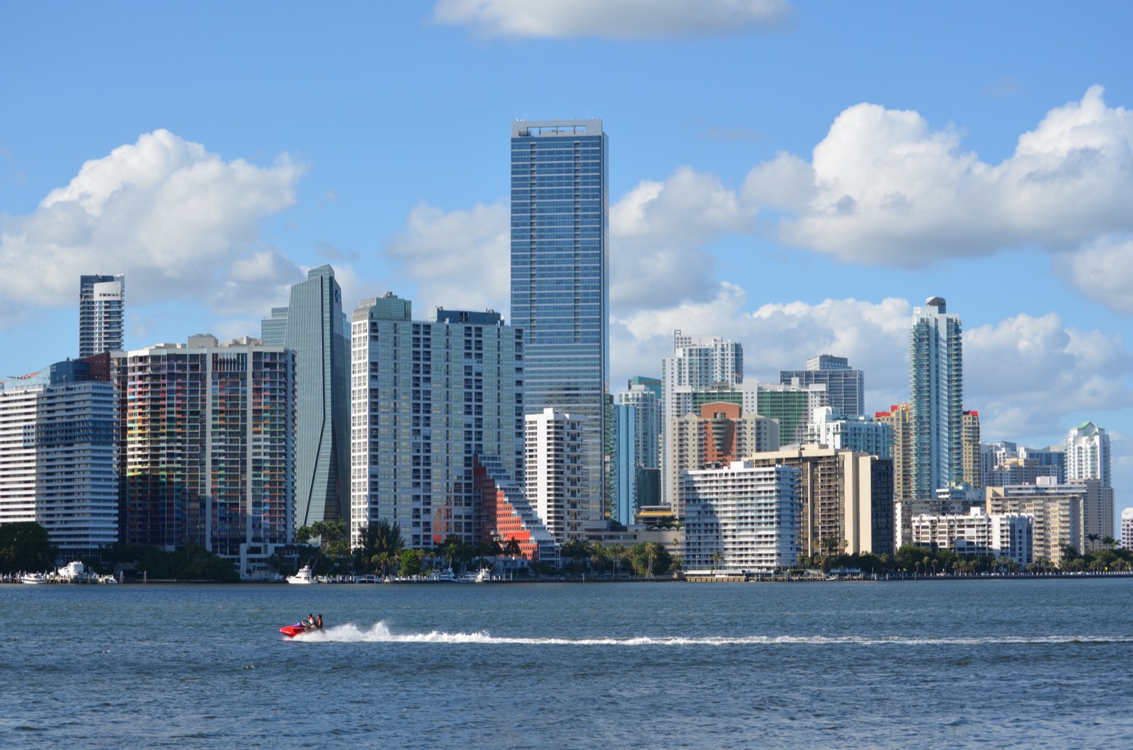 Brickell skyline, Miami's financial district, seen from the Rickenbacker Causeway with a speedboat on Biscayne Bay