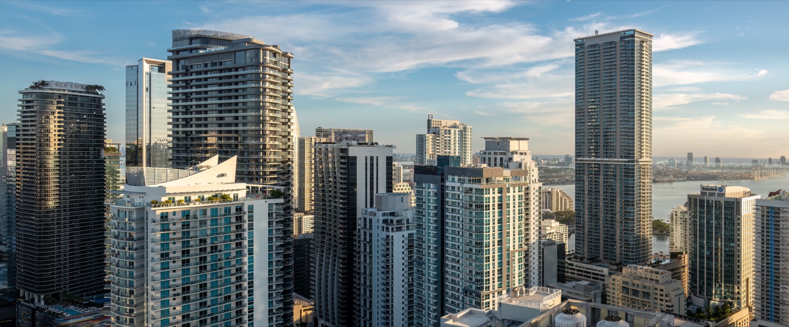 Brickell high-rises in Miami seen from above at dawn, with Biscayne Bay in the background
