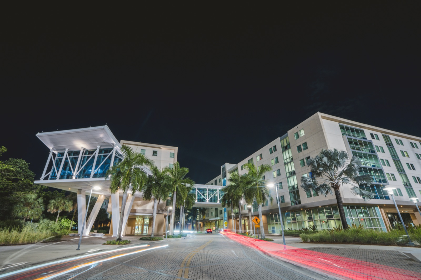 Facade of Parkview Hall, an FIU residence hall, with its white entrance canopy lit at night