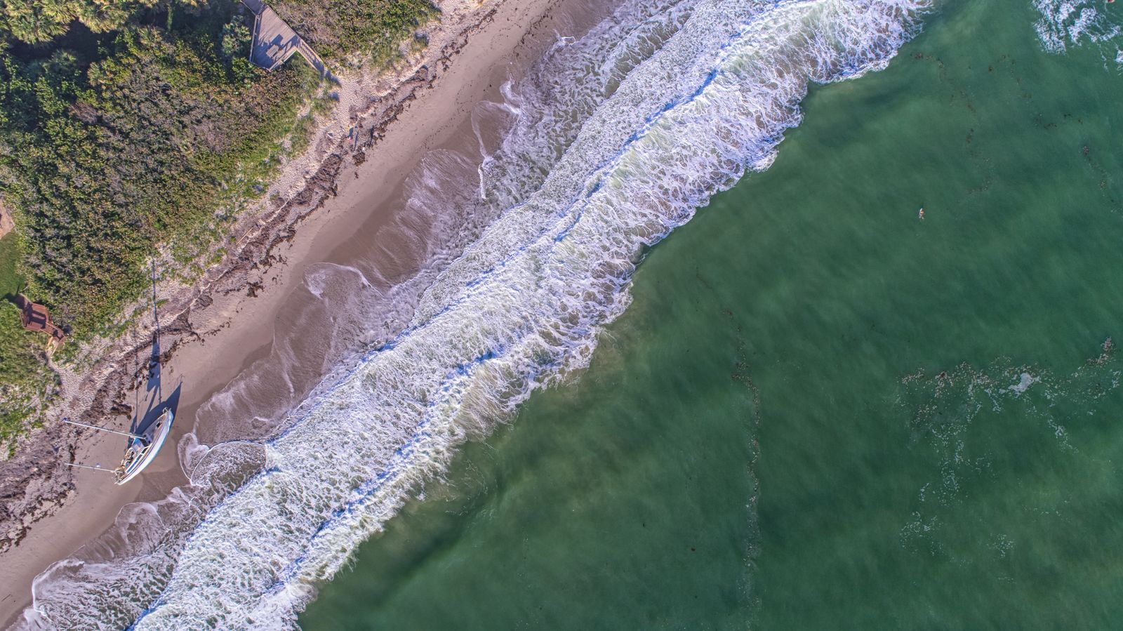 Aerial view of the beach at Melbourne Beach, Florida, with waves breaking on the sand