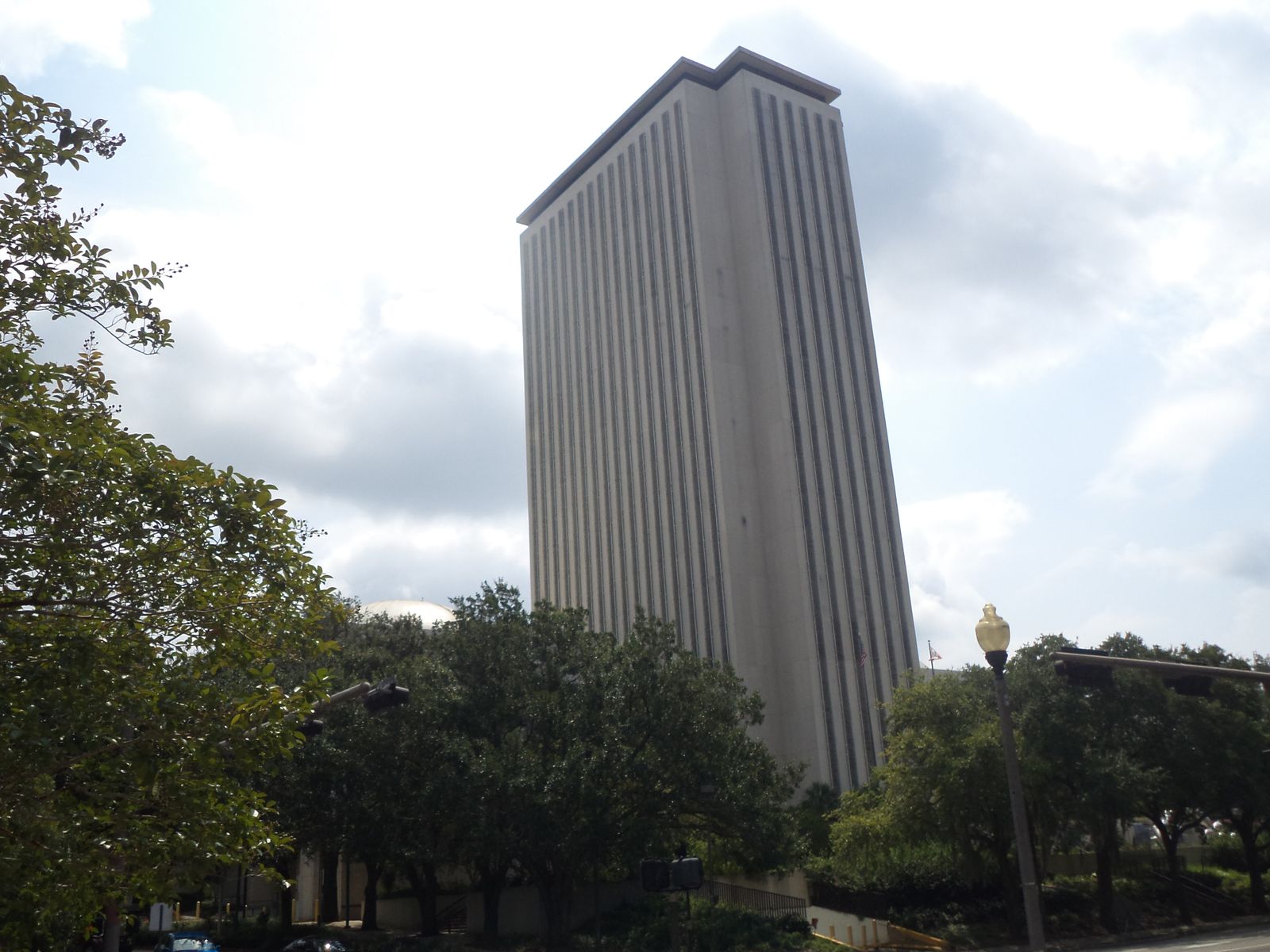 The 22-storey Florida Capitol tower seen from Kleman Plaza, between trees, in downtown Tallahassee
