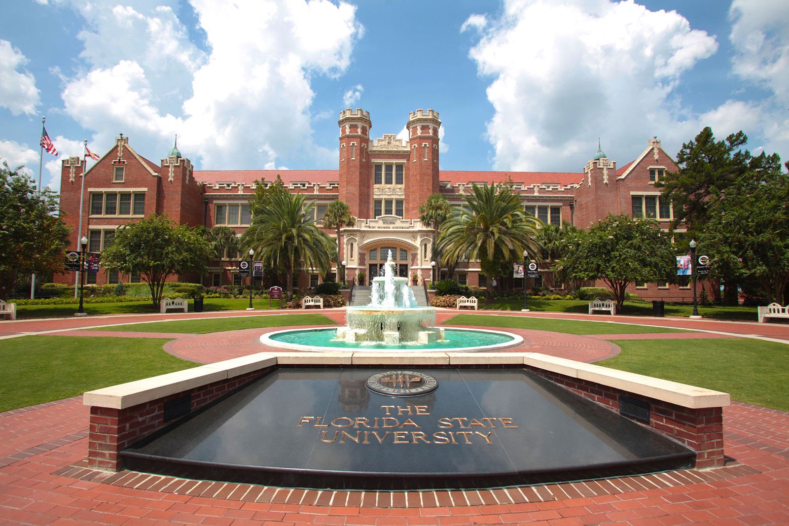 The Westcott Building, Florida State University's twin-towered brick landmark, with Westcott Fountain and The Florida State University sign in the foreground on a blue-sky day in Tallahassee