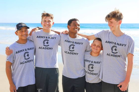 Cinco cadetes sorrindo juntos na praia em Carlsbad