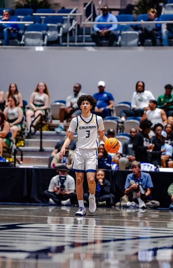 Jogador de basquete número 3 da CCA Eagles conduzindo a bola na final estadual de 2026, diante da torcida