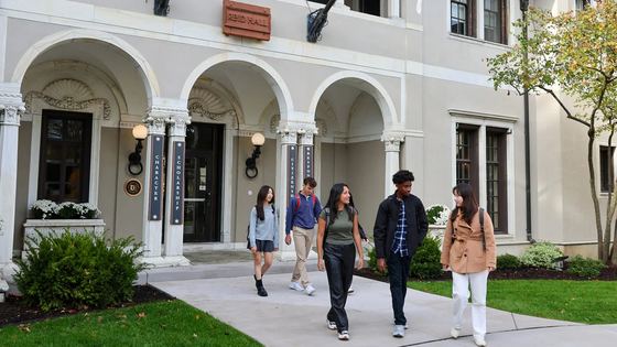 Cinco alunos saindo do Reid Hall entre as aulas