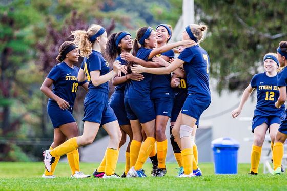 Time feminino de futebol da Storm King comemorando juntas