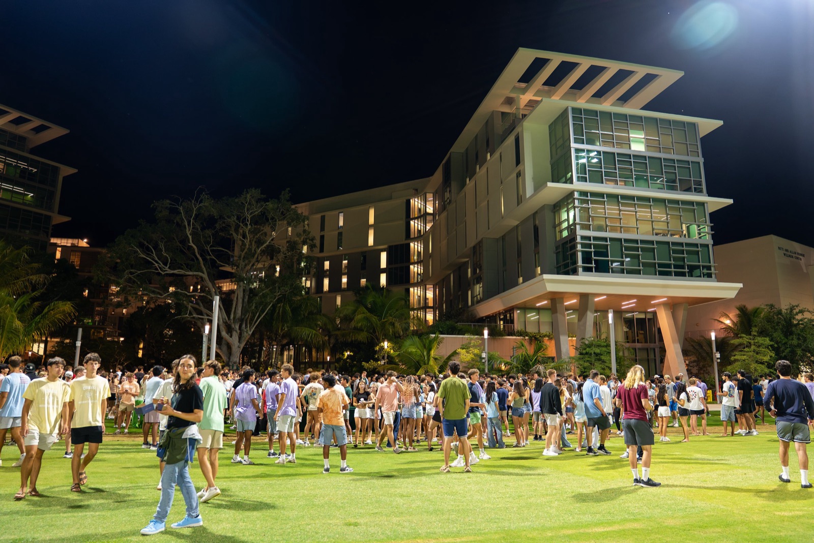 Students gathered at night on the lawn in front of Lakeside Village, a University of Miami residence complex