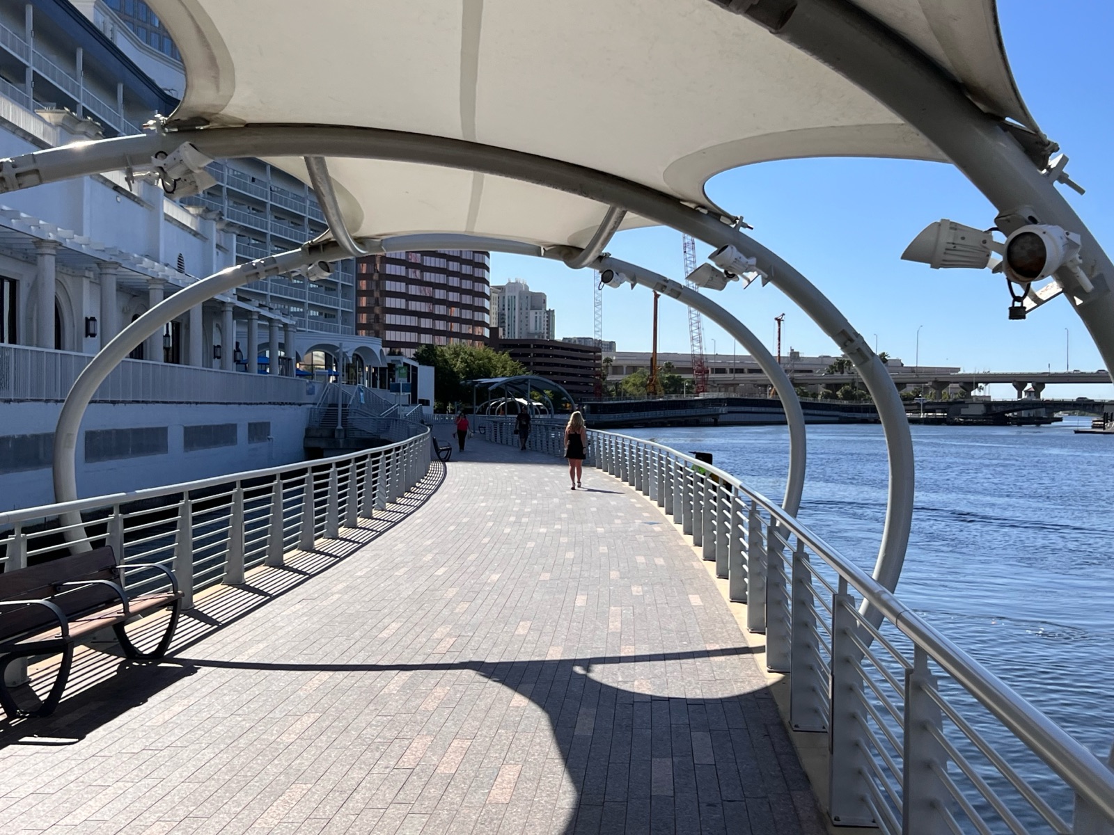 Trecho coberto do Tampa Riverwalk à beira do rio Hillsborough, com o centro de Tampa ao fundo
