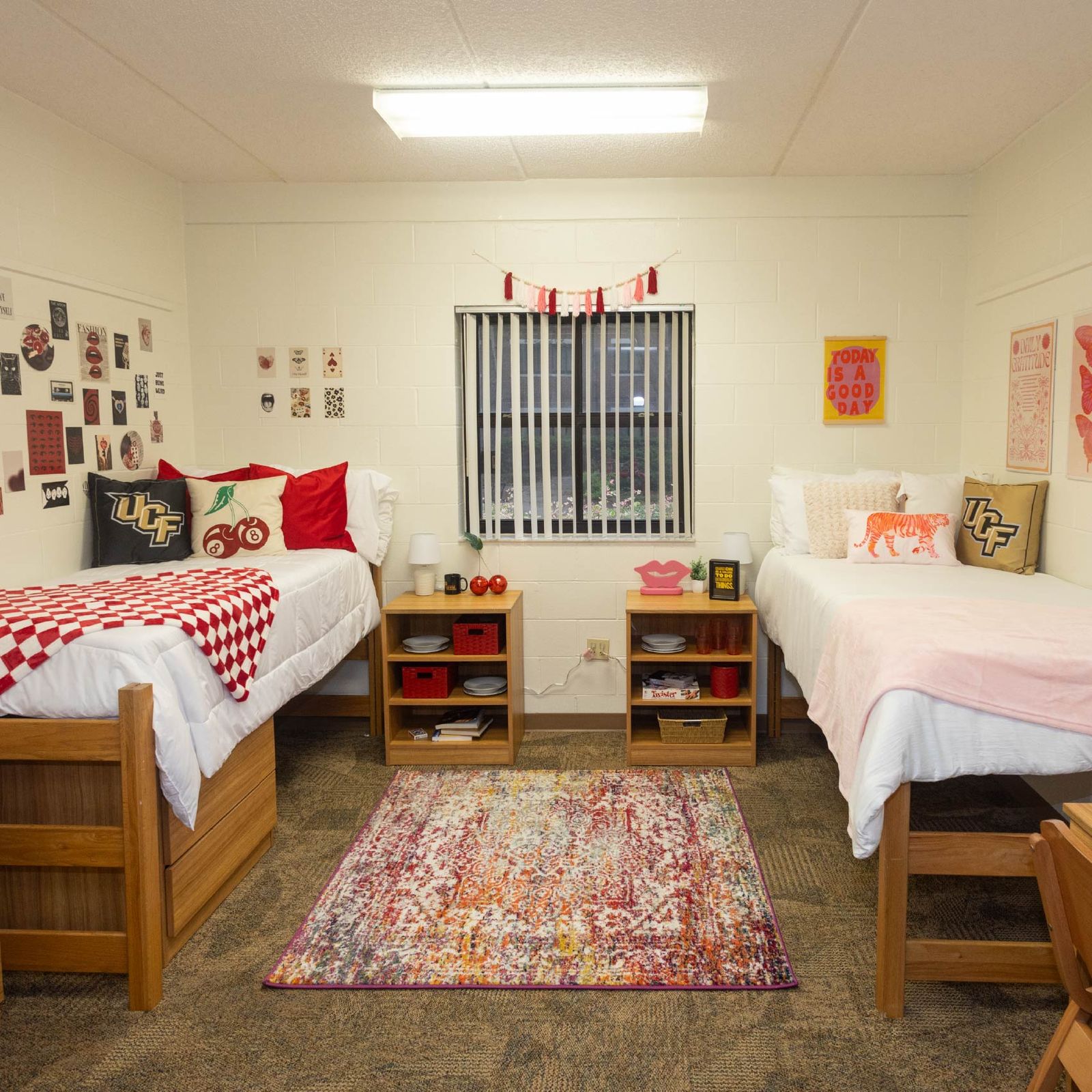 Double room in a UCF residence hall with two beds, desks and red-and-white decor