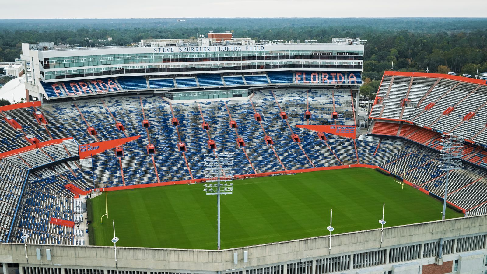 Aerial view of Ben Hill Griffin Stadium, "The Swamp", with its blue-and-orange stands and empty field at the University of Florida