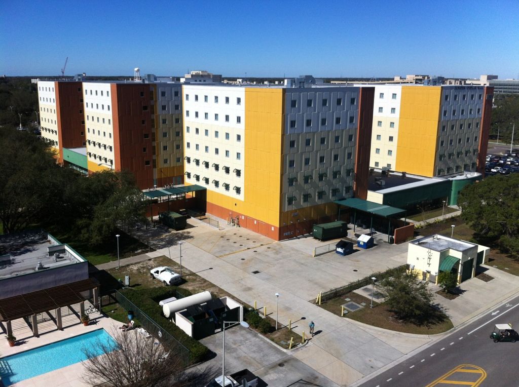 Juniper-Poplar Hall, USF's yellow-and-orange residence hall in Tampa, with the pool in the foreground