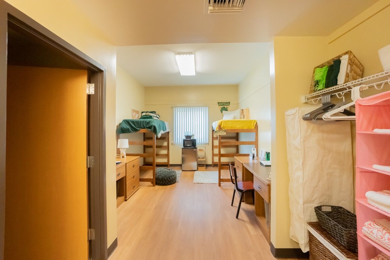 Double room in Juniper-Poplar Hall with two lofted beds, desks, a mini fridge and USF-colored bedding