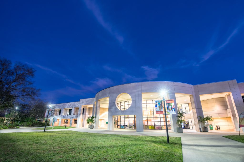 Prédio com janela circular do East Campus da Valencia College iluminado ao anoitecer
