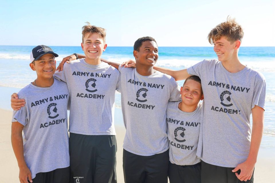 Cinco cadetes sorrindo juntos na praia em Carlsbad