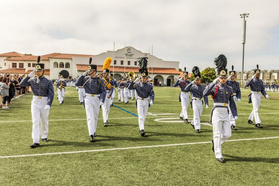 Corpo de cadetes em uniforme de gala e barretinas em desfile