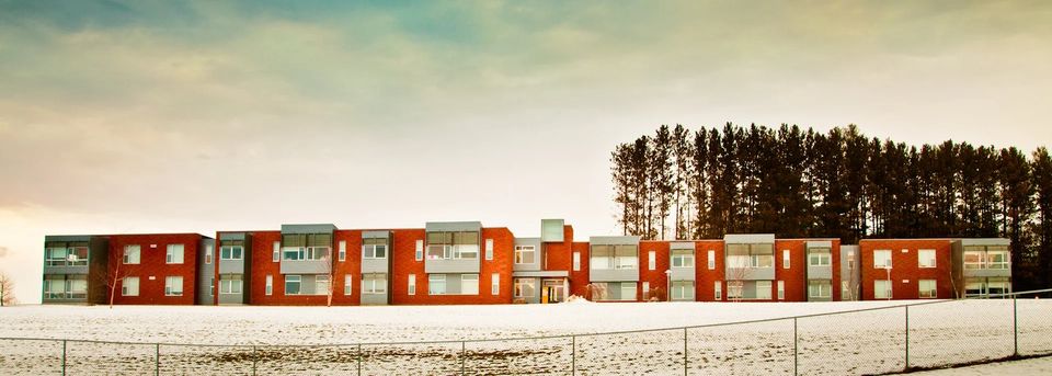 Fachada dos alojamentos de tijolo vermelho em um dia de neve
