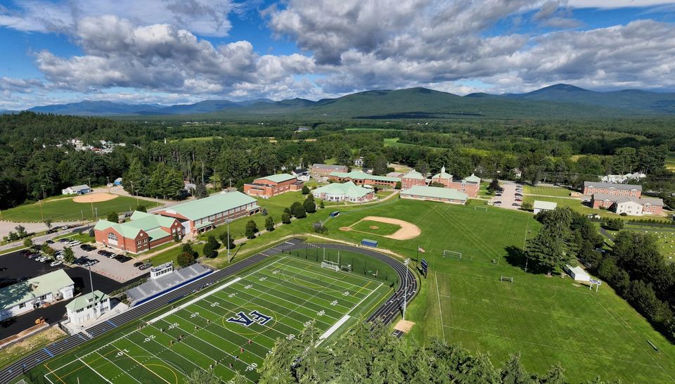 Vista aérea do campus com o campo de futebol americano e as montanhas ao fundo