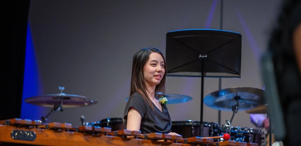 Aluno tocando marimba em apresentação no palco