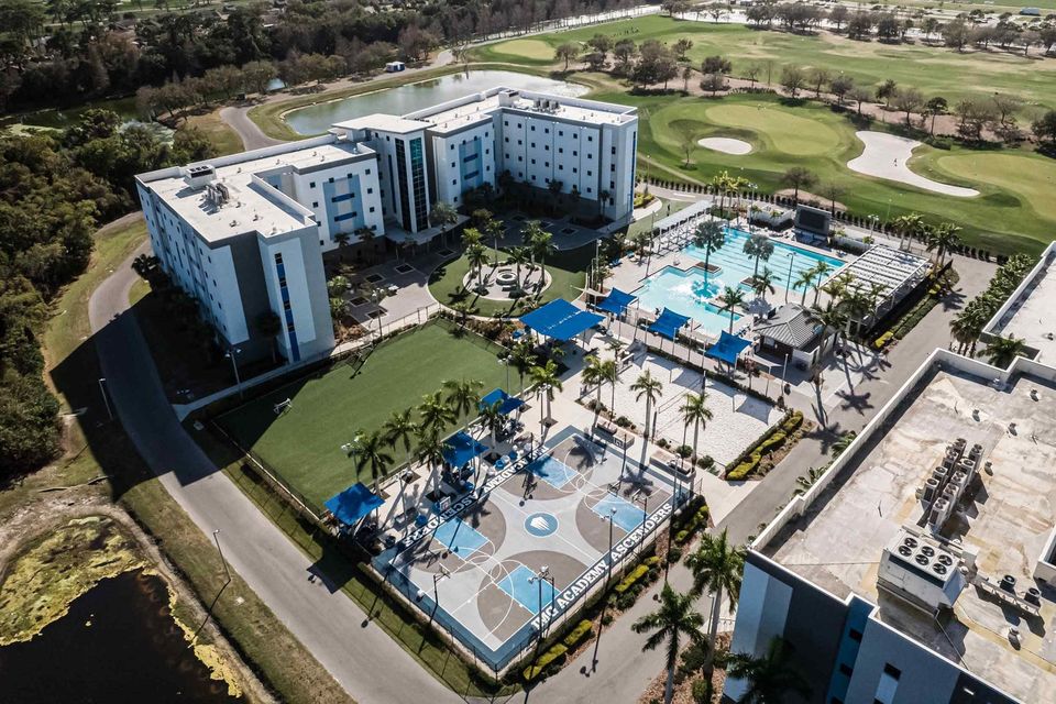 Vista aérea dos residenciais Ascender Hall com piscina, campo sintético e quadra de basquete ao lado do campo de golfe