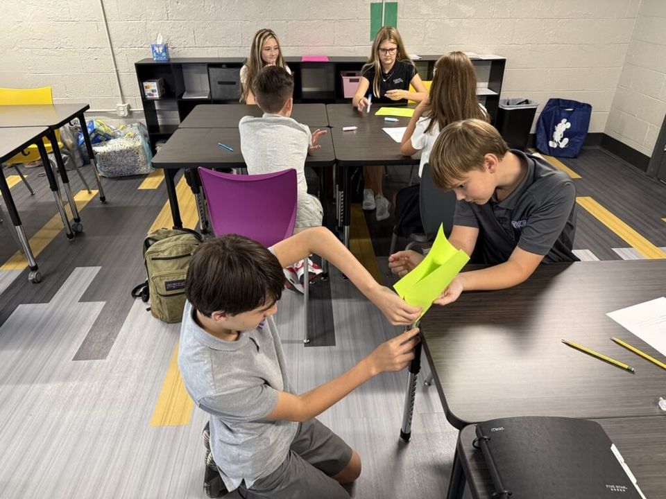 Alunos do ensino médio trabalhando em grupo em uma sala de aula
