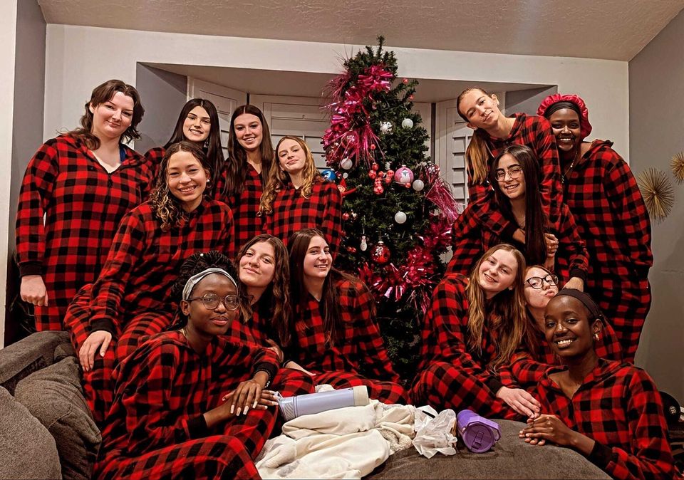 Meninas de pijama xadrez vermelho em volta de uma árvore de Natal em uma casa residencial da LCA