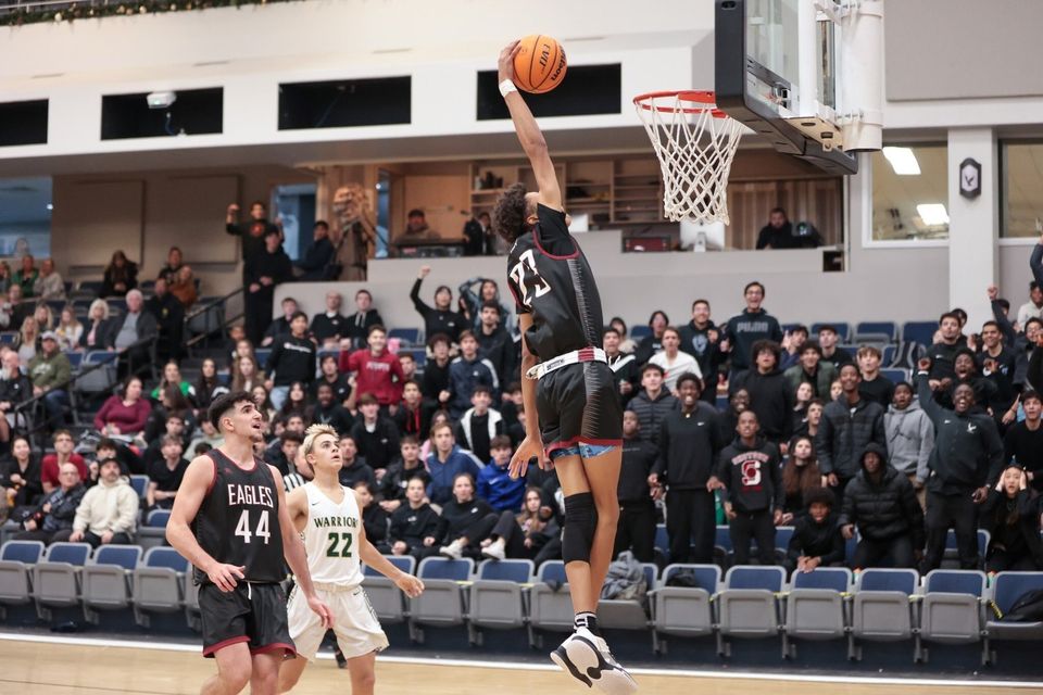 Jogador de basquete da LCA enterrando a bola diante da torcida lotada