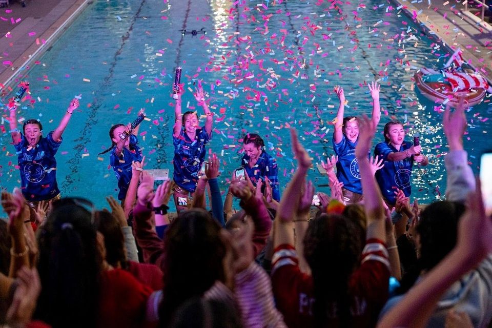 Equipe de natação comemorando na piscina com confete