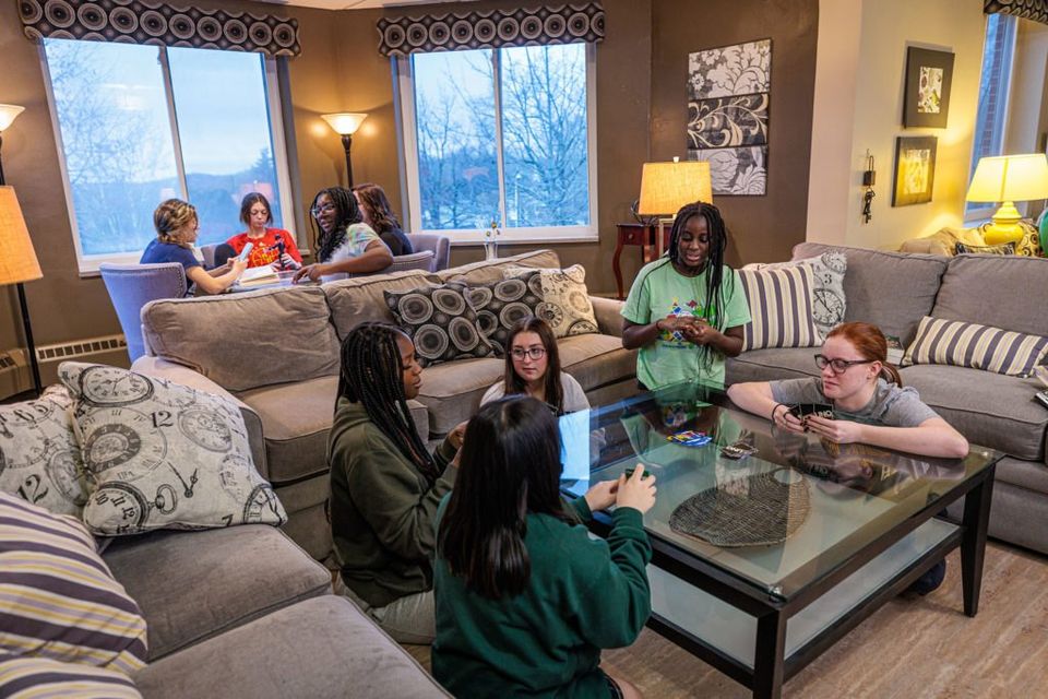 Meninas conversando relaxadas nos sofás da sala comum do dormitório