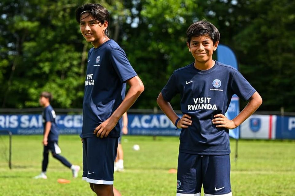 Dois jovens jogadores de uniforme da PSG Academy Pro sorrindo durante o treino