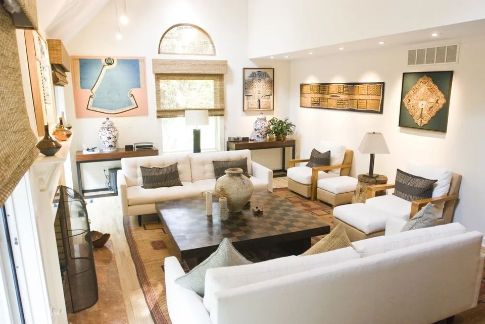 Sala de estar de uma casa de internato, com sofás brancos e quadros na parede