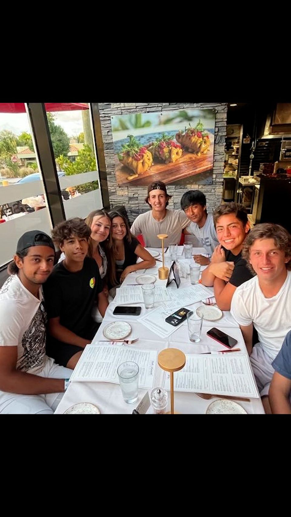 Grupo de alunos em um jantar de equipe em um restaurante