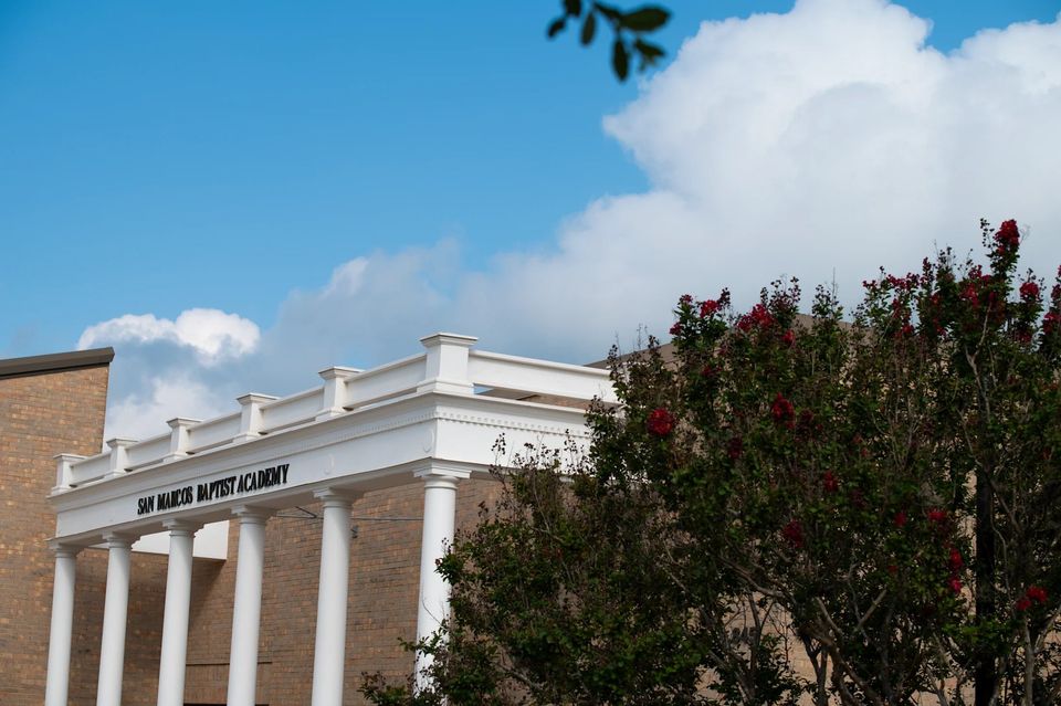 Fachada de colunas brancas do prédio histórico da San Marcos Baptist Academy no campus