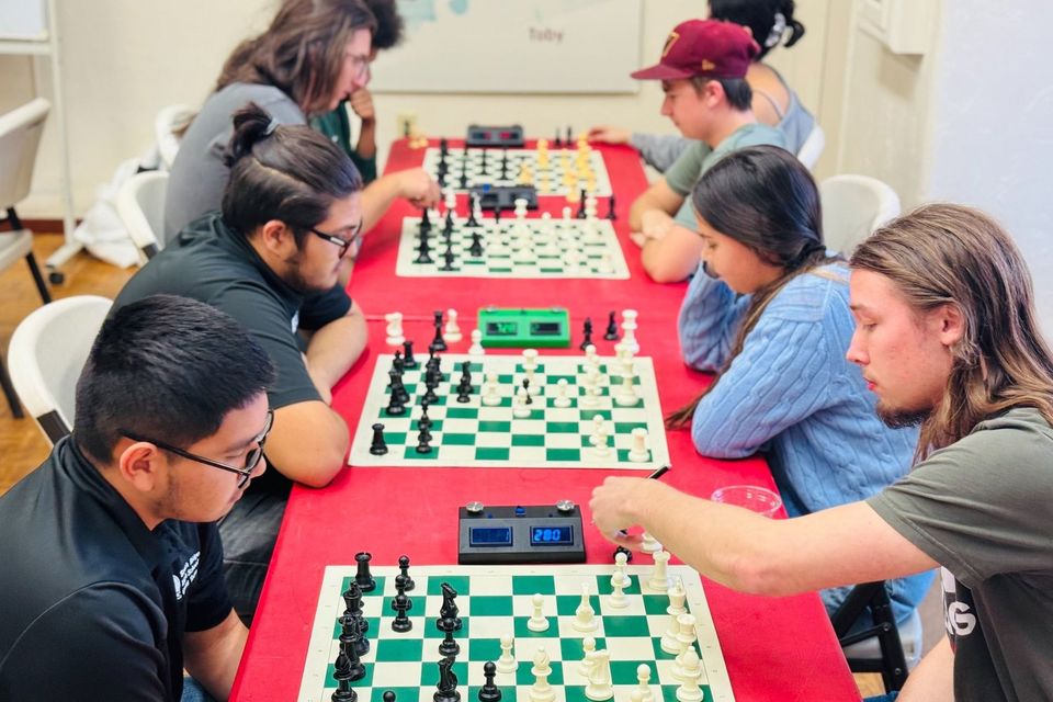 Alunos jogando xadrez em uma mesa comprida (equipe de xadrez)