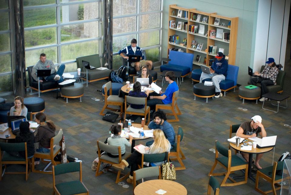 Estudantes estudando em mesas e poltronas na biblioteca do campus de Boca Raton da FAU durante a semana de provas finais